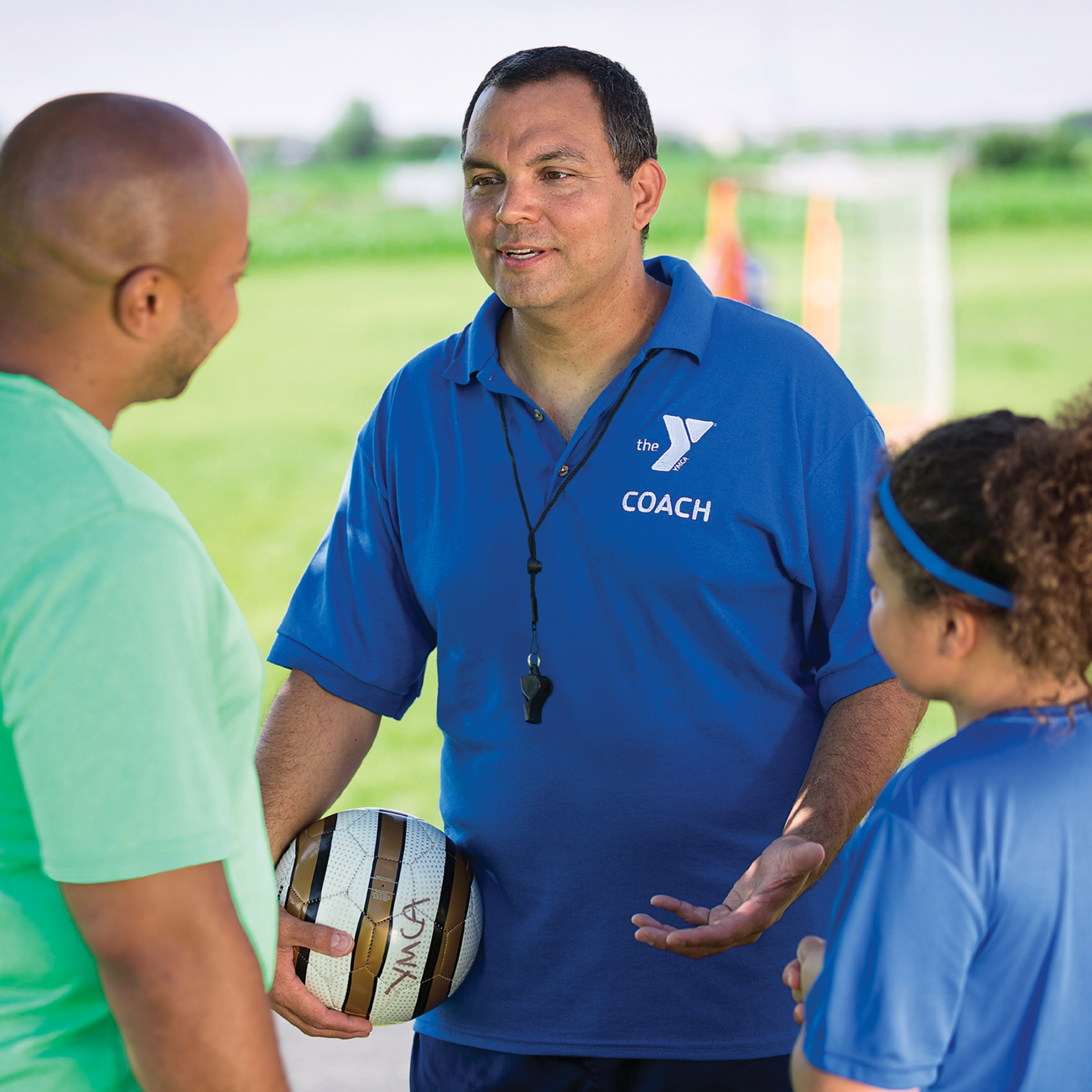 a YMCA coach talking to a parent