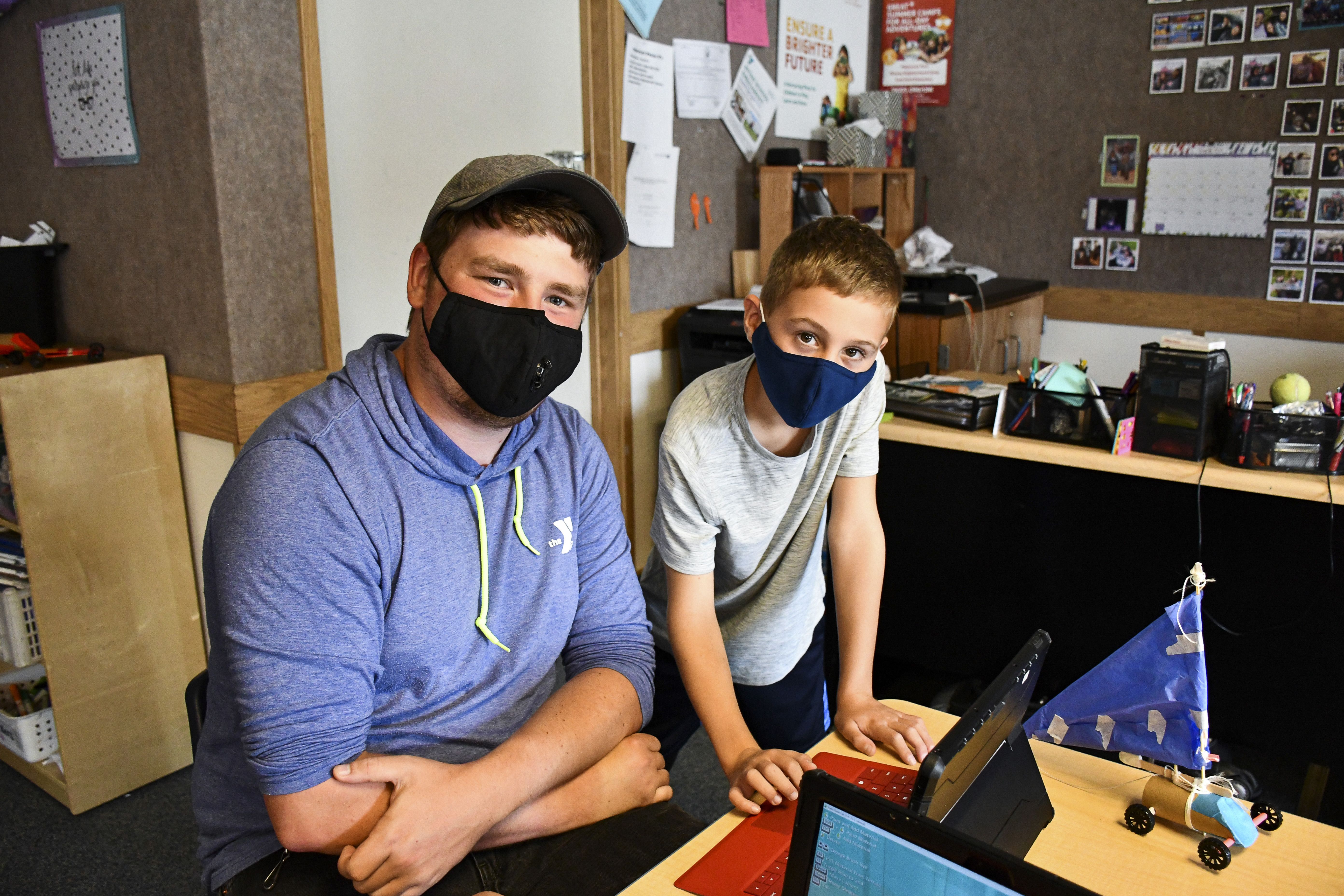Staff Member and boy working at table