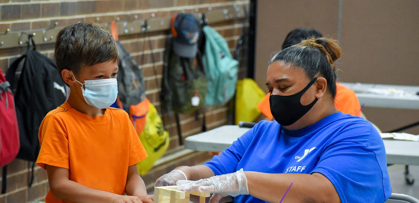 Staff member engaged in activity with young boy