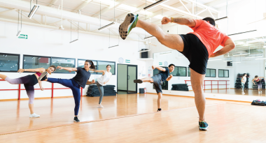 A group of people take a ymca kickboxing class.