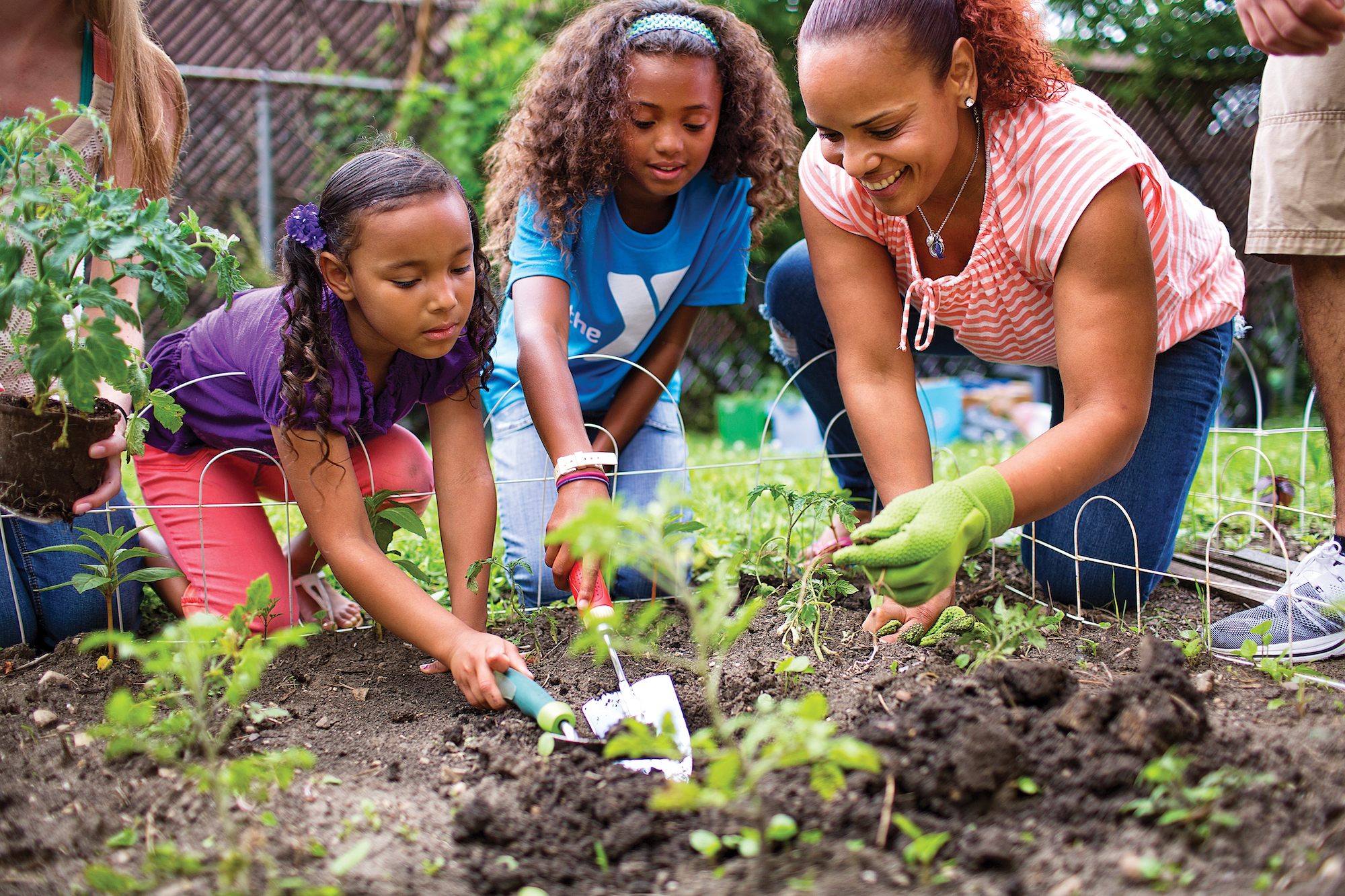 woman and children planting a garden