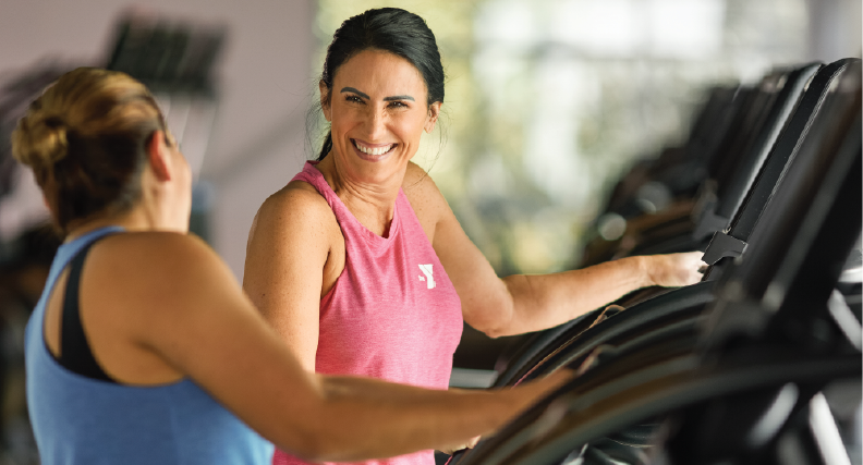 two women work out in a ymca fitness center on treadmills
