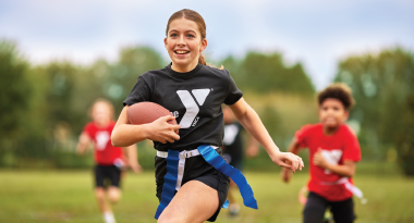 a girl scores a goal in a ymca flag football game