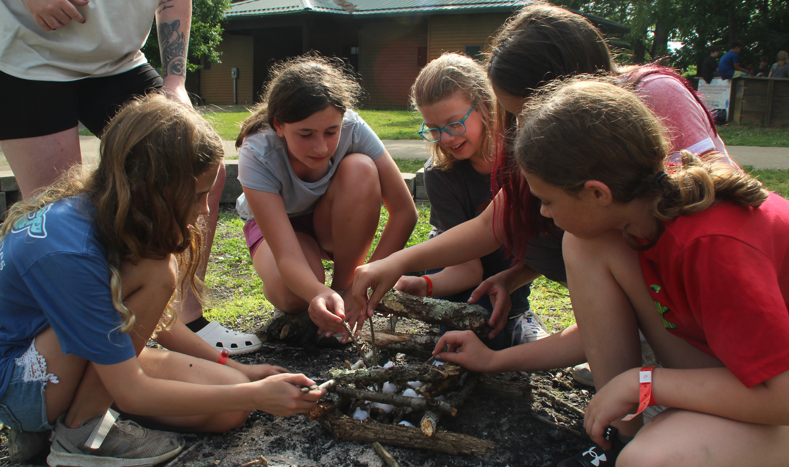 girls building a campfire