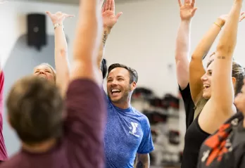 ymca instructor and members high fiving