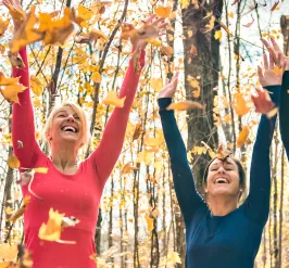 Happy women with arms up in woods