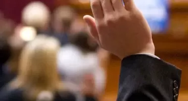 A hand being raised in a court room.