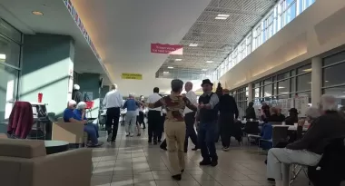 A group of active older adults dance in the ymca lobby