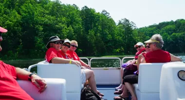 YMCA Trout Lodge Adult Trippers ride on a pontoon boat on the lake