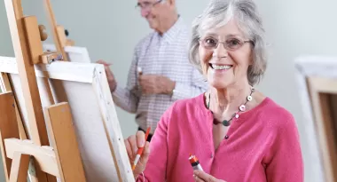 A group of seniors paint canvases at the ymca