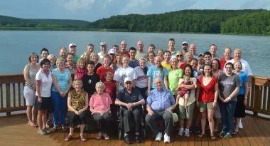 An image of a huge family taking a group picture during their family reunion on the deck at Trout Lodge. 