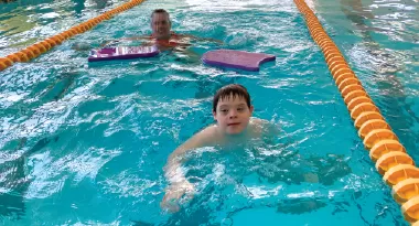 andrew, integrated fitness participant, swims in a Y pool with his ymca support teammate