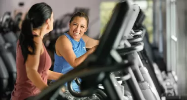 two women work out on a treadmill in a ymca fitness center while building friendship