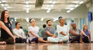 participants in a ymca group exercise yoga and pilates class stretching
