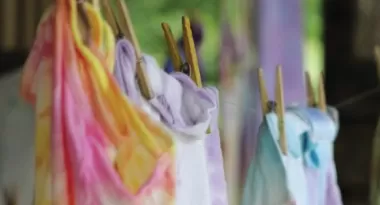 tie dyed shirts hanging out to dry with clothespins