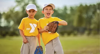 two ymca youth sports baseball friends smile at a t-ball game