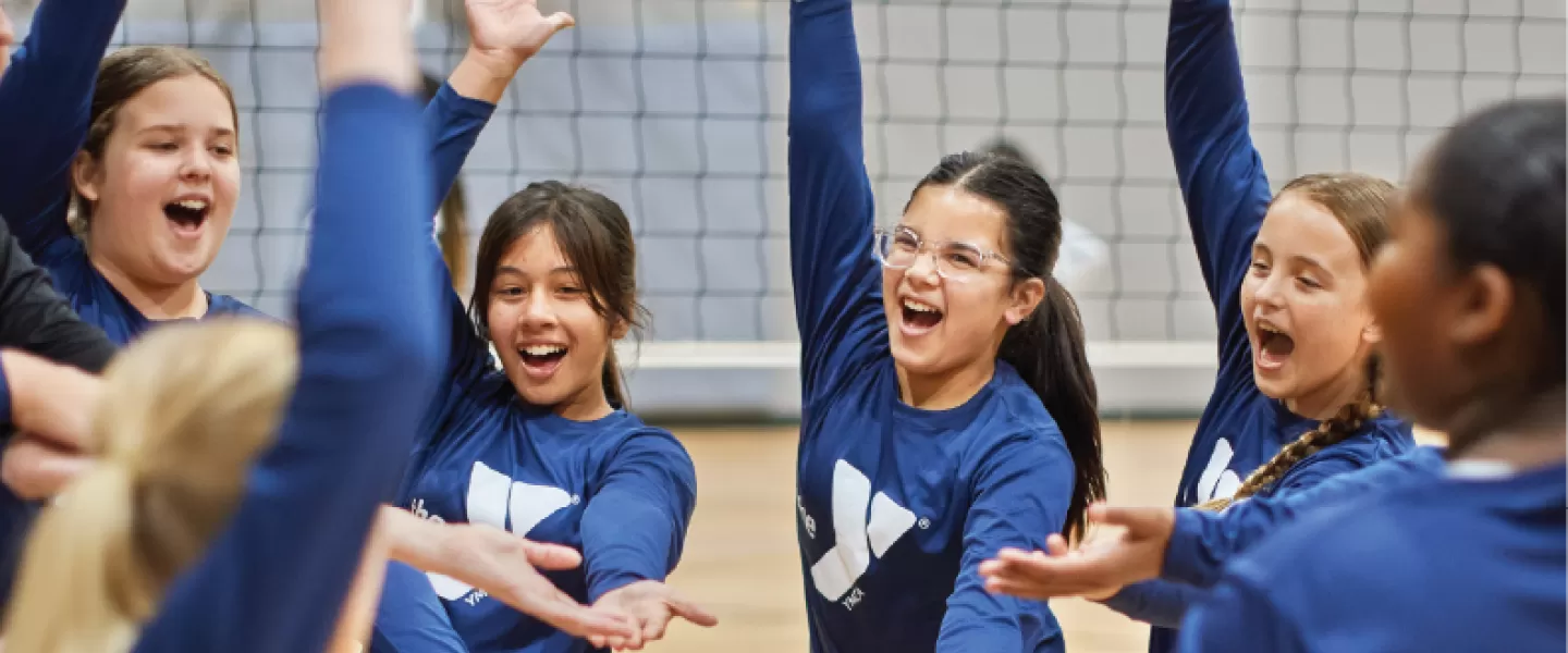 ymca youth volleyball team cheering during a volleyball game