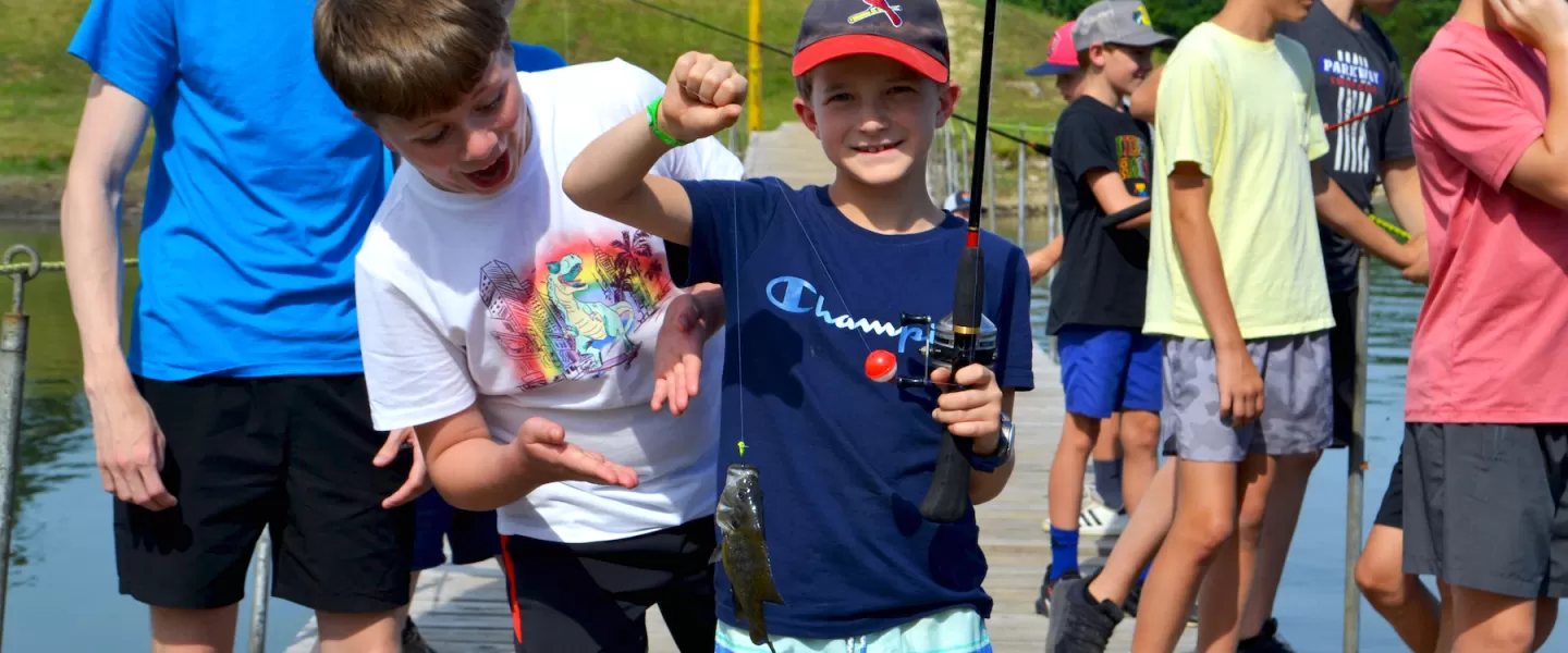 ymca camp lakewood boy fishing with a fish he caught