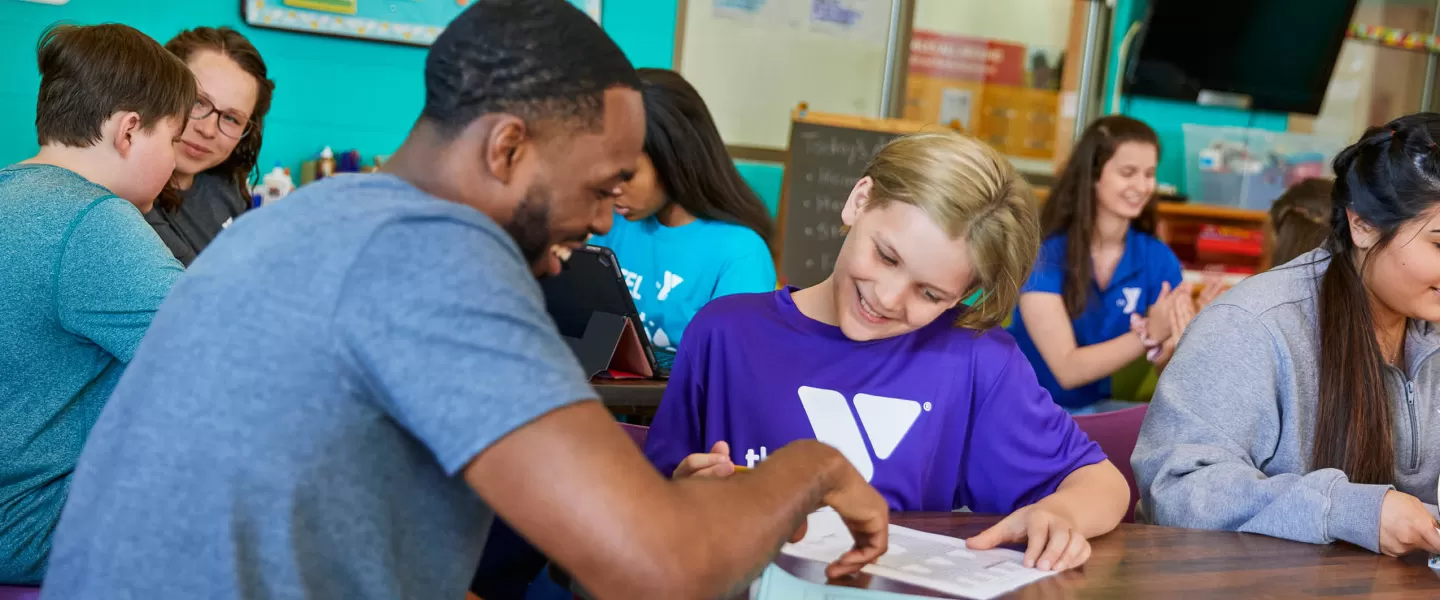 ymca staff teaching student enrolled in summer school y club