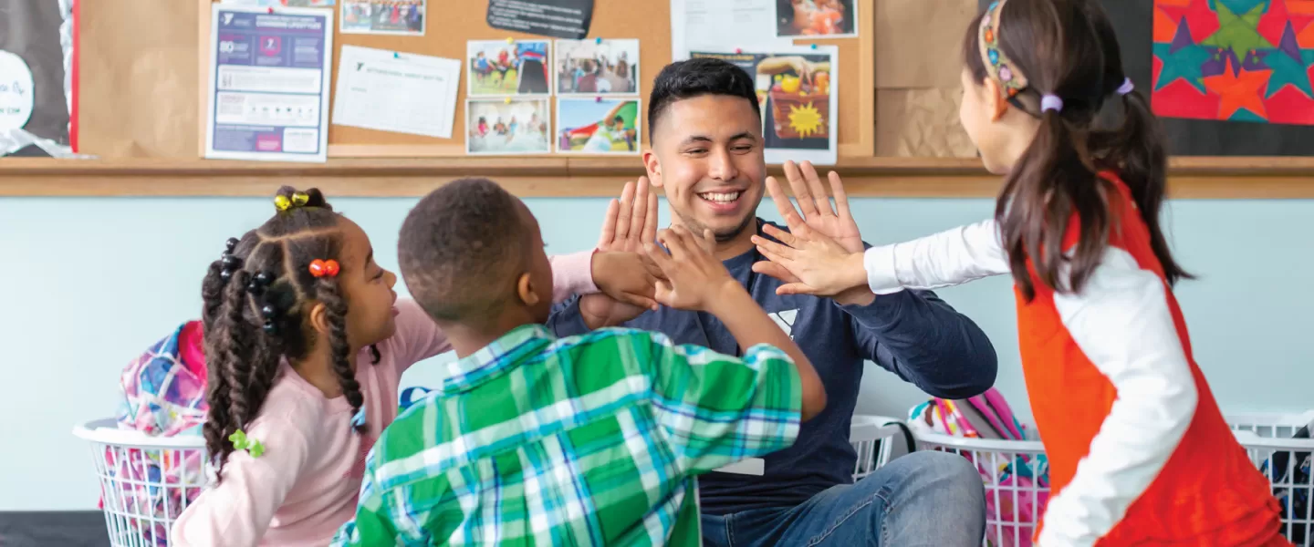 y employee high fiving kids in child care