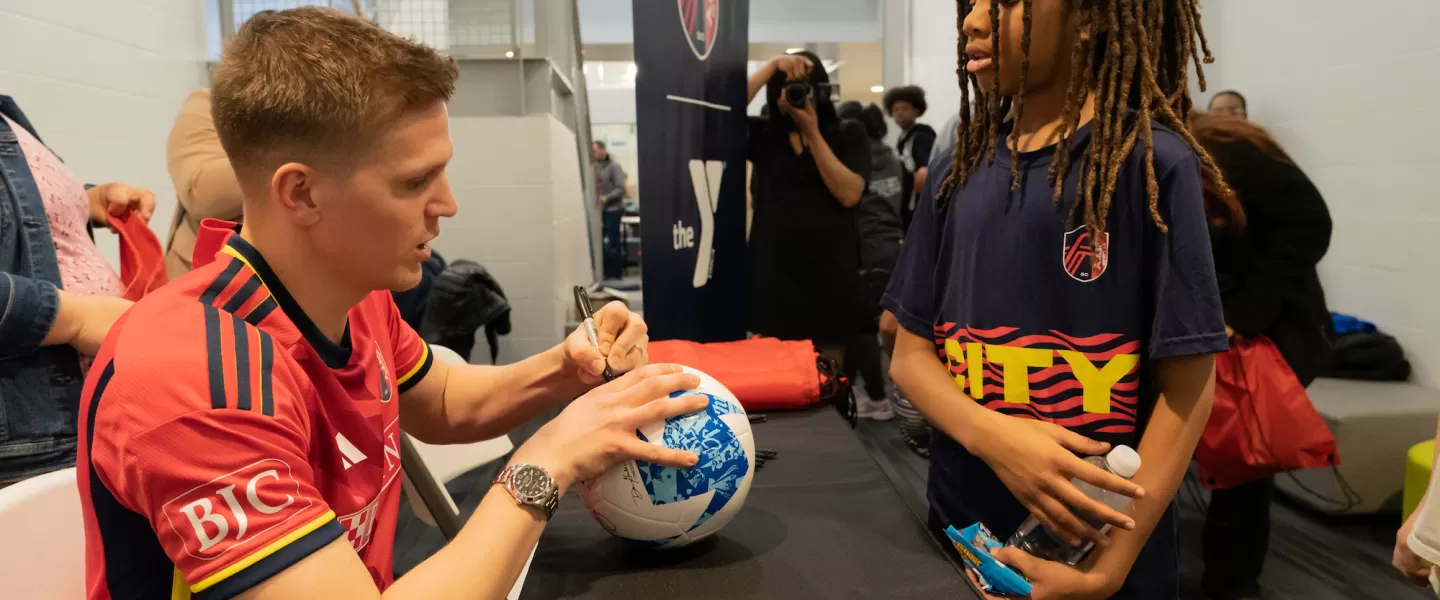 St. Louis CITY SC Player Signing a Soccer Ball for YMCA Youth Sports Participant