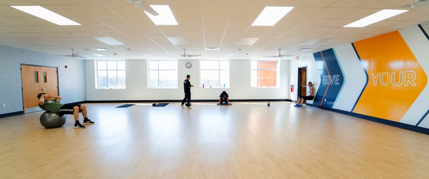 Chesterfield Family YMCA Newly Renovated Group Exercise Studio with new flooring, wall graphics, lighting, and equipment.