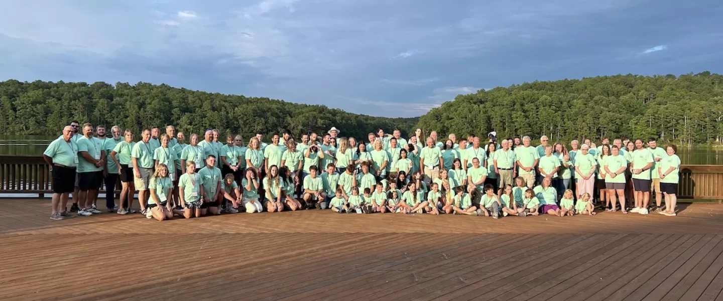 Family reunion posing for a group photo on the Trout Lodge deck in front of Sunnen Lake