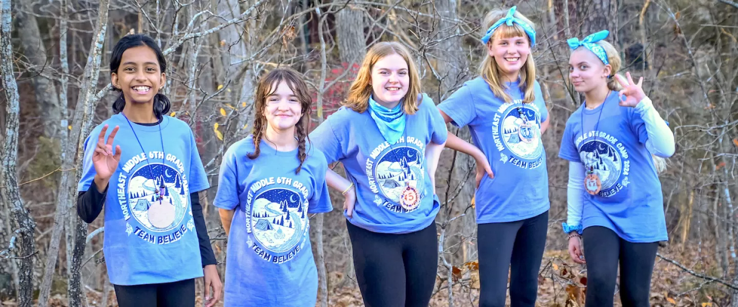 Group of smiling students posing together outdoors during Outdoor Education camp