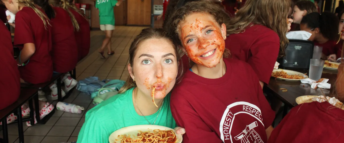 A happy camper and counselor enjoying the famous 'utensils optional' Sunday Night Spaghetti dinner.