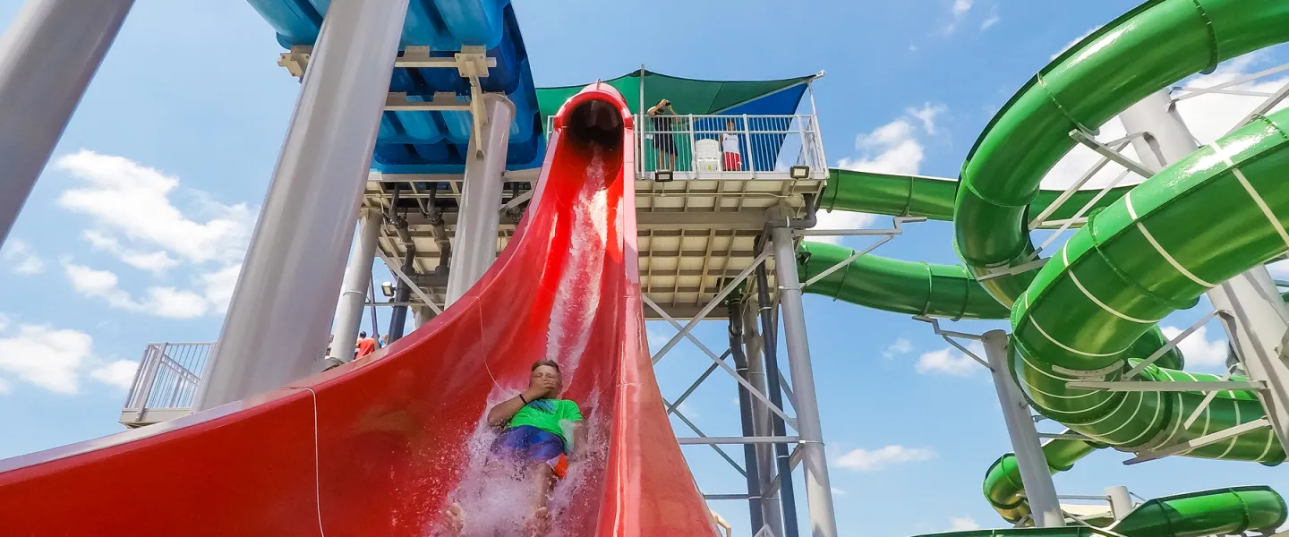 An exciting moment as a rider splashes into the catch pool upon exiting the large red tube water slide at the Ste. Genevieve YMCA.