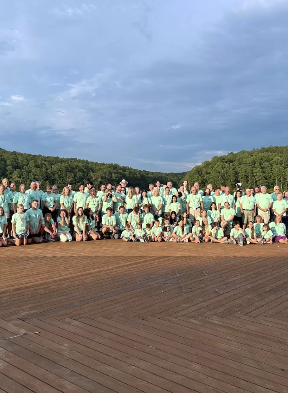 Family reunion posing for a group photo on the Trout Lodge deck in front of Sunnen Lake