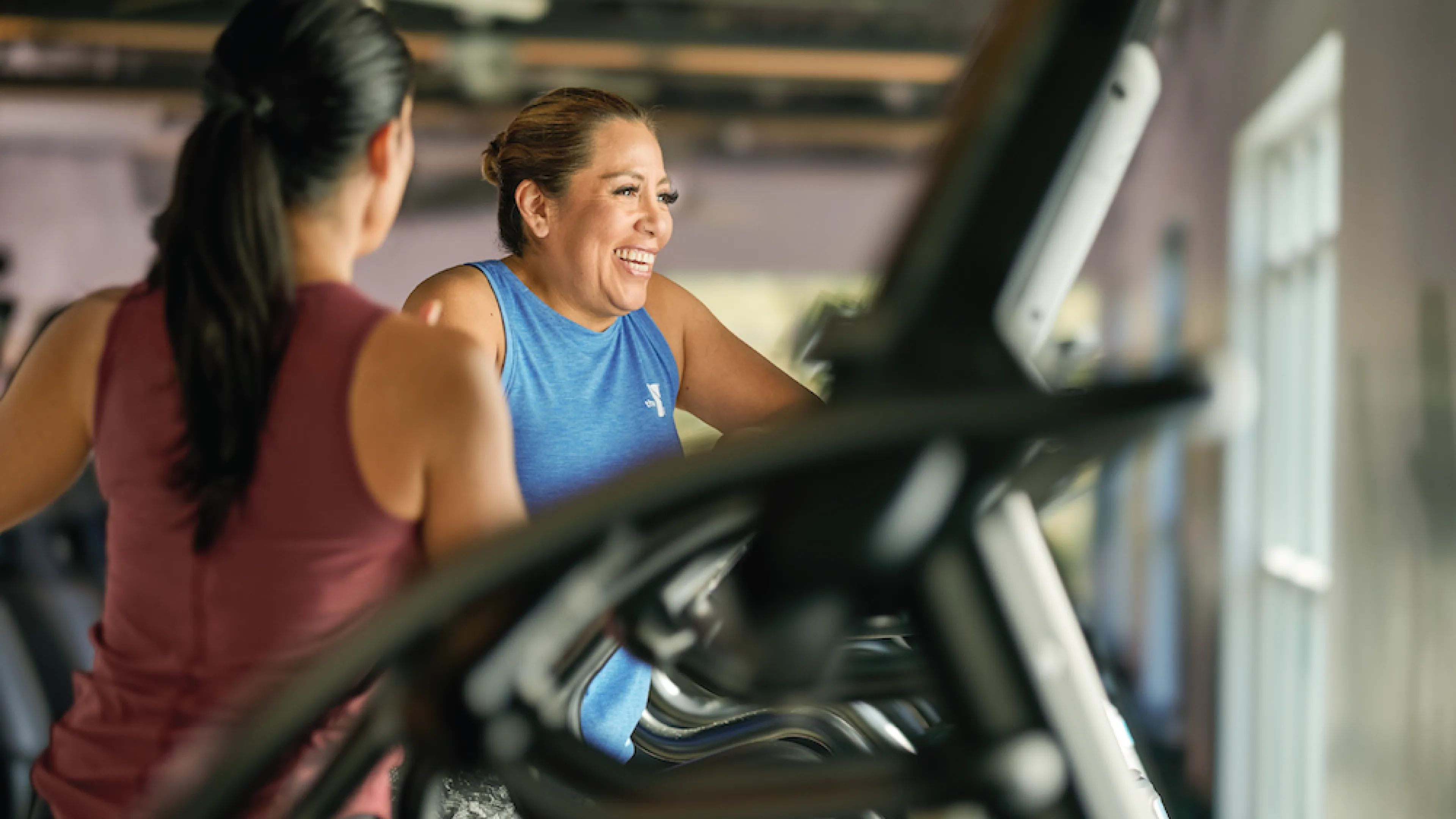 Two Females on YMCA Corporate Memberships Working Out on Elliptical Machines
