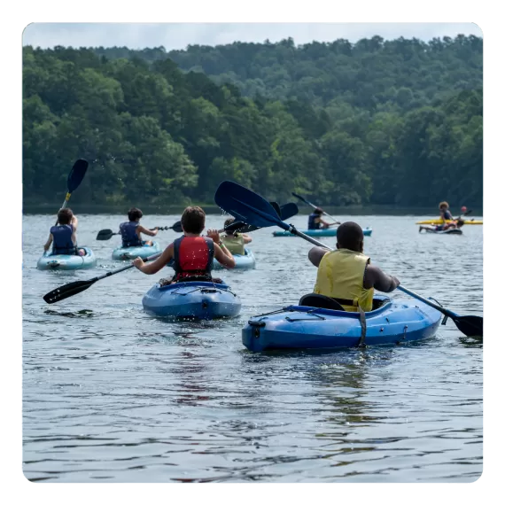 a group of campers at ymca camp lakewood kayaking on the private lakewood lake 