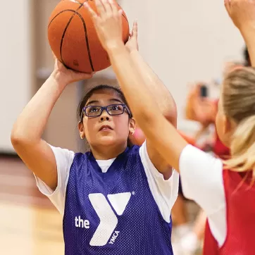 girl shooting basketball