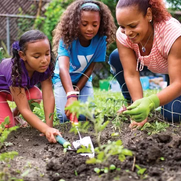 woman and children planting a garden