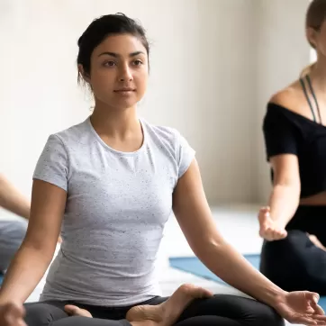 woman practicing meditation in a yoga class for her mental health