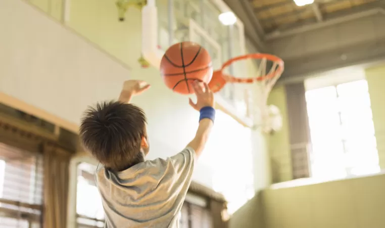 child shooting a basketball