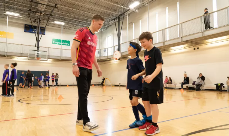 Joakim Nilsson, CITY SC defender, talks with two young YMCA soccer players