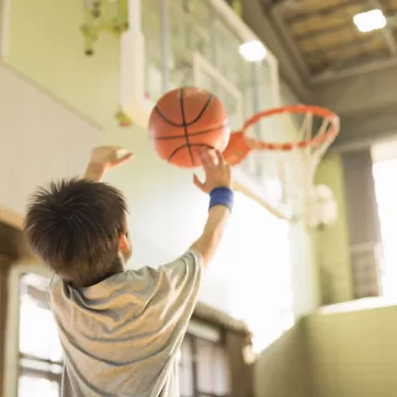 child shooting a basketball