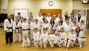 Thumbnail: An image of the martial arts instructors and students taken at a YMCA. All students and instructors alike are wearing karate uniforms and there's an array of belt colors captured.