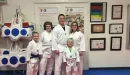 Thumbnail: A Caucasian female from the YMCA participates in karate lessons together. The grandma, mom, dad, and two young sons are captured wearing  white karate uniforms in the image.