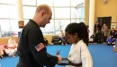 Thumbnail: An African American girl receives her black belt from her Caucasian male instructor from her karate class at the YMCA.