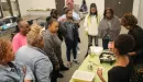 Thumbnail: An image of a group of African American women huddled together around the class instructor's teaching them cooking skills and nutrition facts at the YMCA.