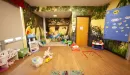 Thumbnail: Child care room with toys, tables and chairs. Brightly painted with fun graphics.