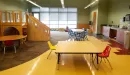 Thumbnail: Child care room with play structure, short tables and chairs, and toys.