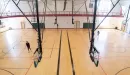 Thumbnail: Two-court gymnasium with basketball hoops. Members playing pickleball on one side. Indoor track above gym.