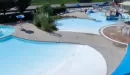 Thumbnail: Outdoor aquatic center showing children's play area and splash pad, large wading pool, lazy river, and large umbrellas.