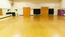 Thumbnail: Large studio room for group exercise classes. Yoga mats hanging on walls. Mirrors throughout.