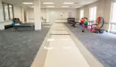 Thumbnail: Spacious stretching area with yoga mats and sitting area. Additional workout equipment along opposite wall.