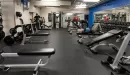 Thumbnail: Free weight area with dumbbells, benches facing mirrors, and weight machines.